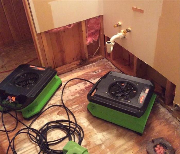 Two fans drying bathroom after demolition.