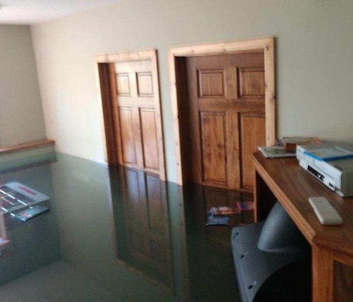 Picture of flooded basement with floating TV after main water pressure tank broke.