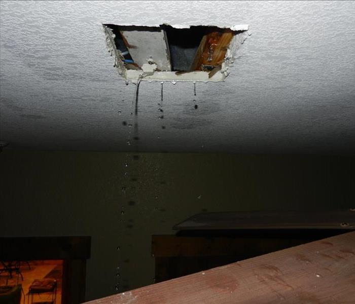 Picture of water leaking out of bedroom ceiling.
