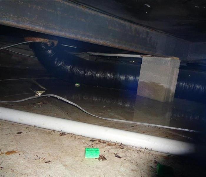 Picture of crawlspace under manufactured home with standing water on concrete base