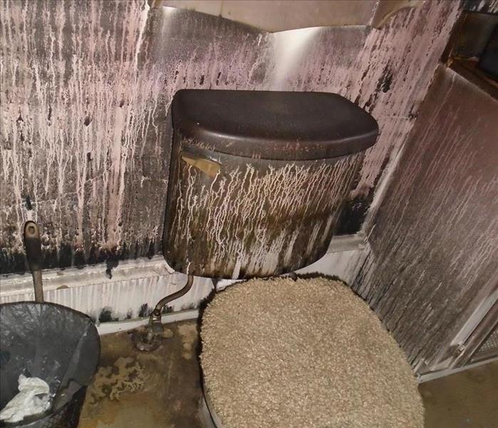 Picture of soot stained bathroom toilet after fire tears through house.