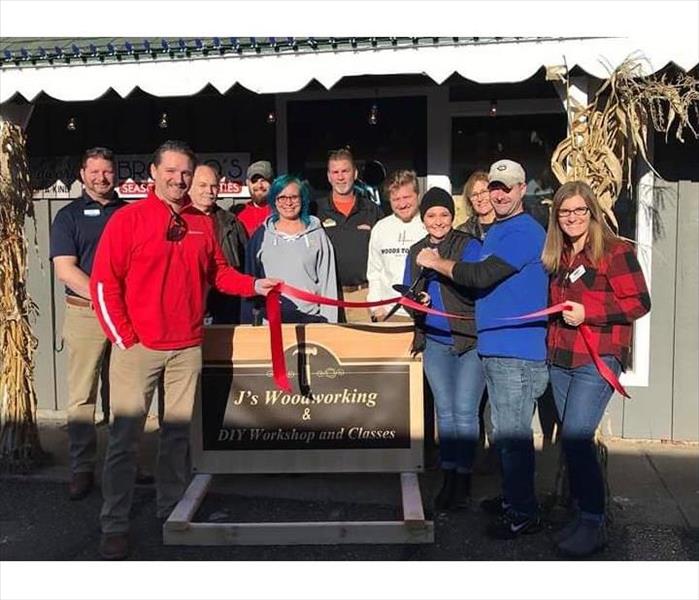 Red ribbon cutting for J's Woodworking with Nisswa Member's in Action.
